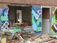829907 Gezicht op de sloopwerkzaamheden aan het pand Aardbeistraat 35 te Utrecht. Het huis is volgespoten met graffiti.
